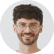 A man with glasses and a beard smiling.