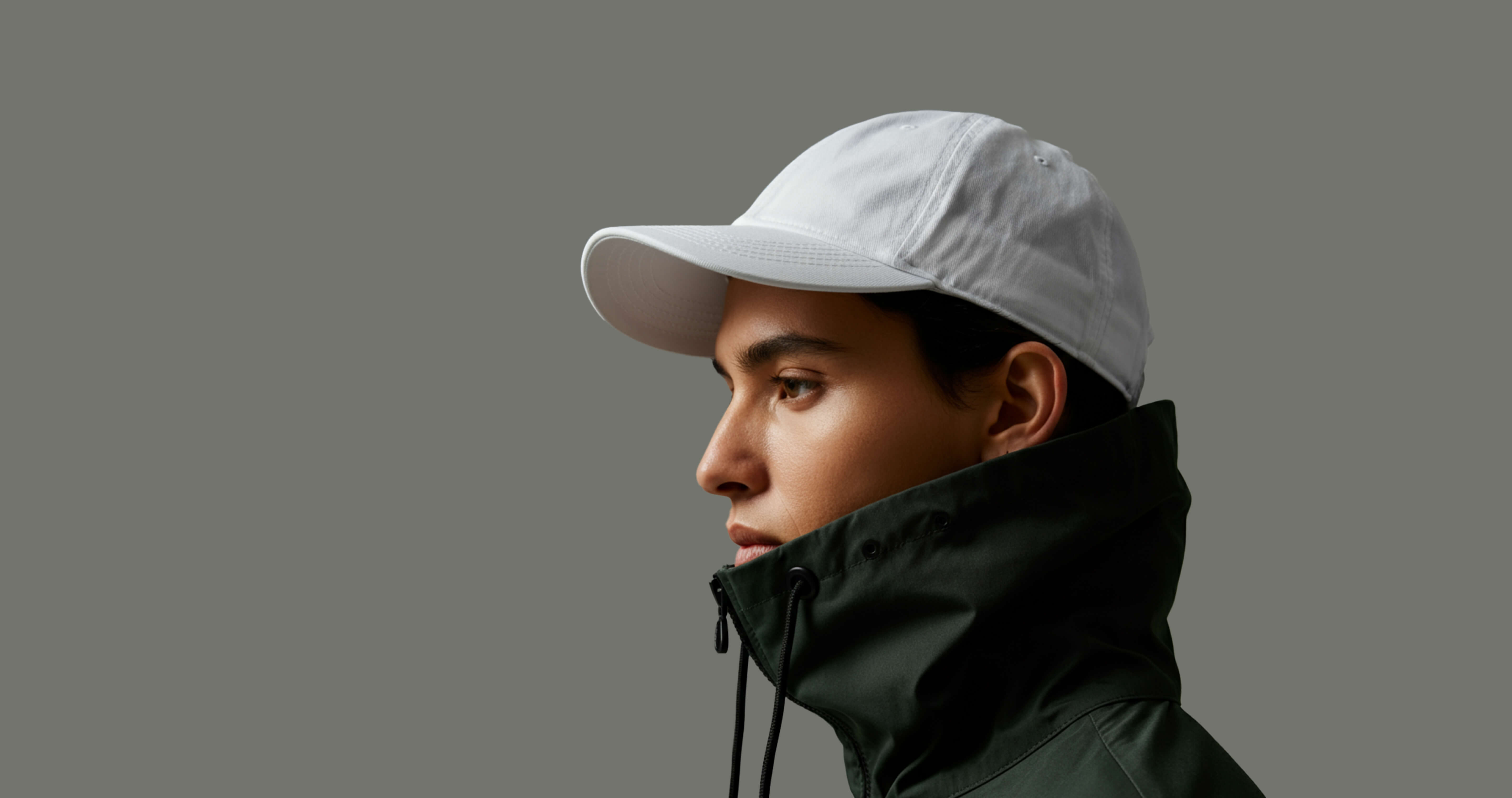 A man wearing a white hat and green jacket.